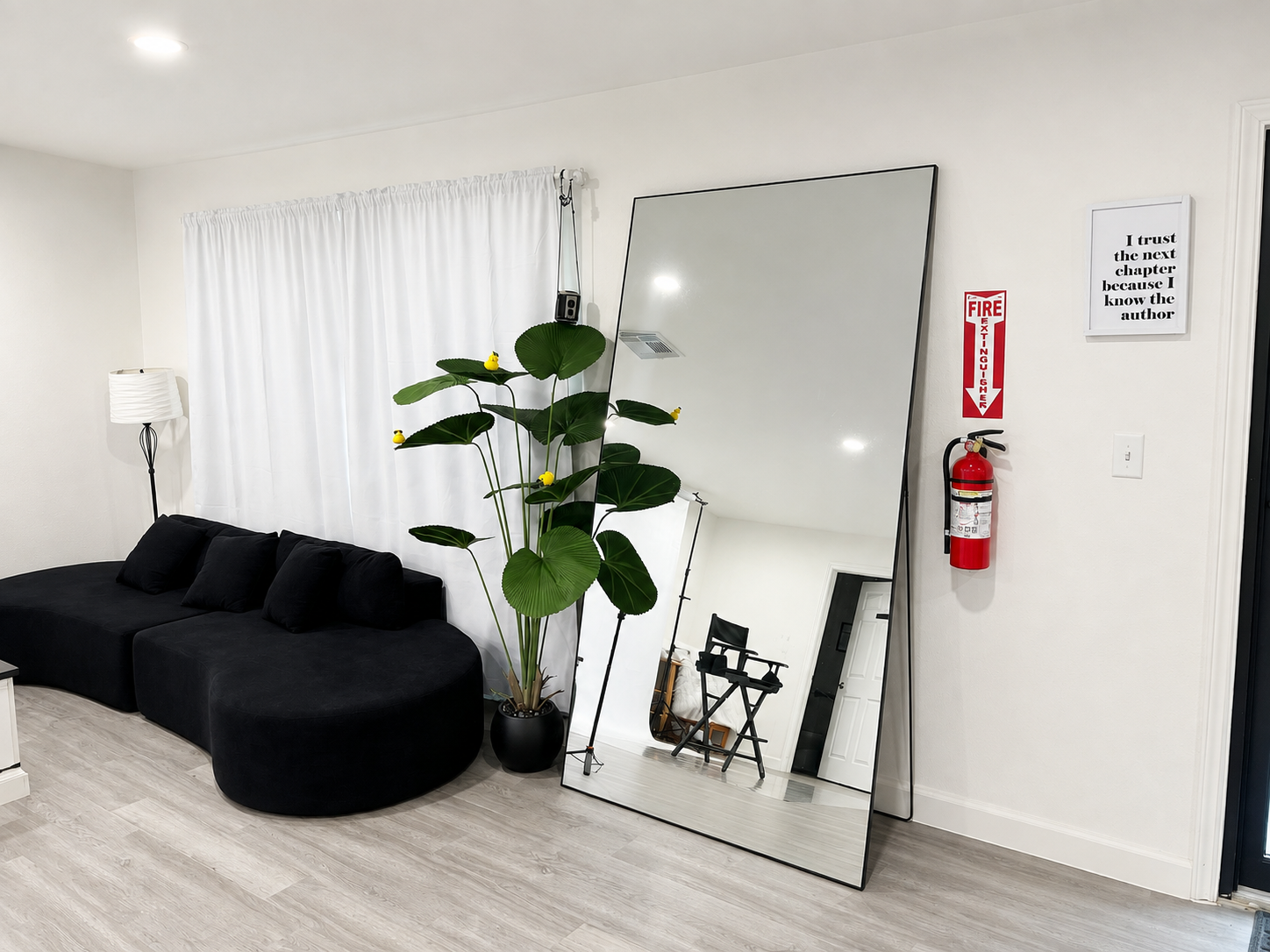 Client waiting area with couch and full-length mirror inside the studio